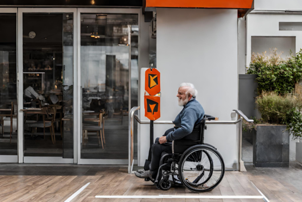 Accessibilité et handicap : personne à mobilité réduite sur une rampe d'accès menant à un restaurant.